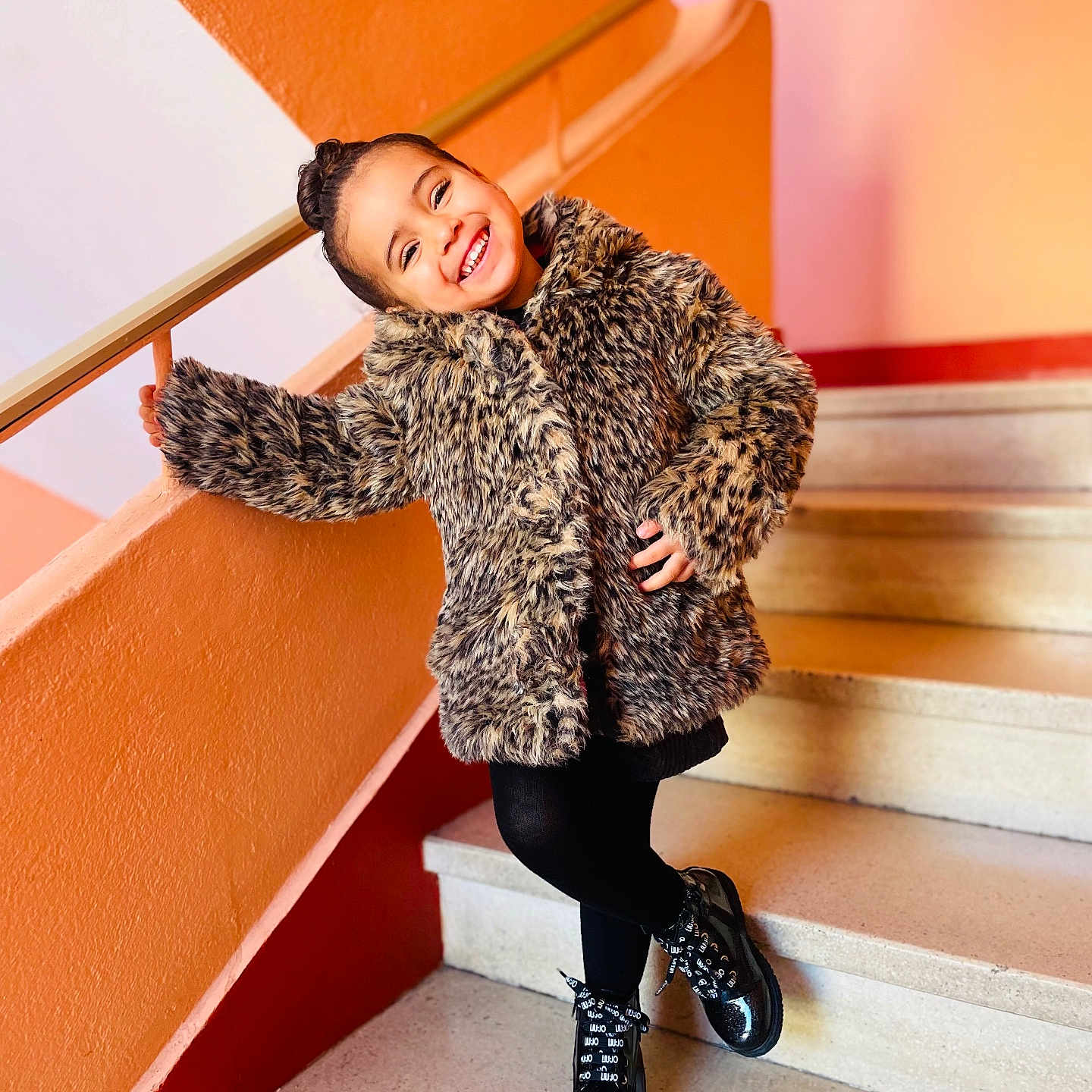 Inaya a rejoint le concours — aidez-le/la à gagner de superbes lots ! architecture, blackhair, building, clothing, coat, face, footwear, hair, handrail, happy, head, house, housing, pants, person, shoe, sitting, sleeve, smile, staircase