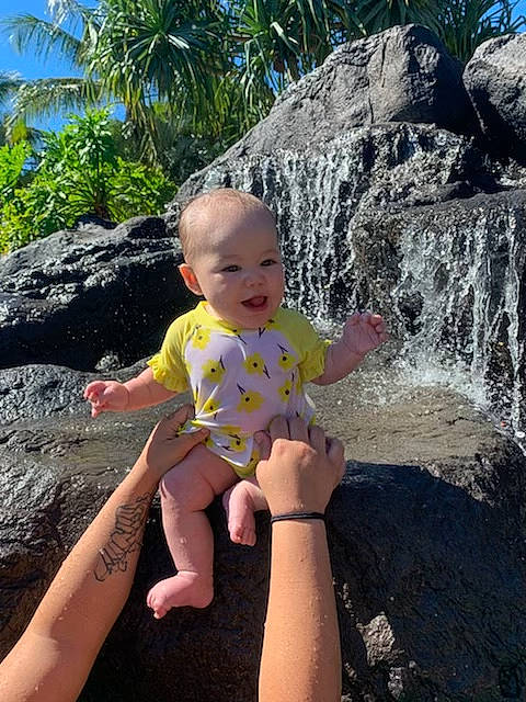 Mila-rose is registered to the contest to win money with this photo: arecales, arm, baby, baby_toddler_clothing, barefoot, finger, foot, fun, hand, leisure, palm_tree, person, rock, sitting, summer, thumb, toddler, toe, tropics, vacation