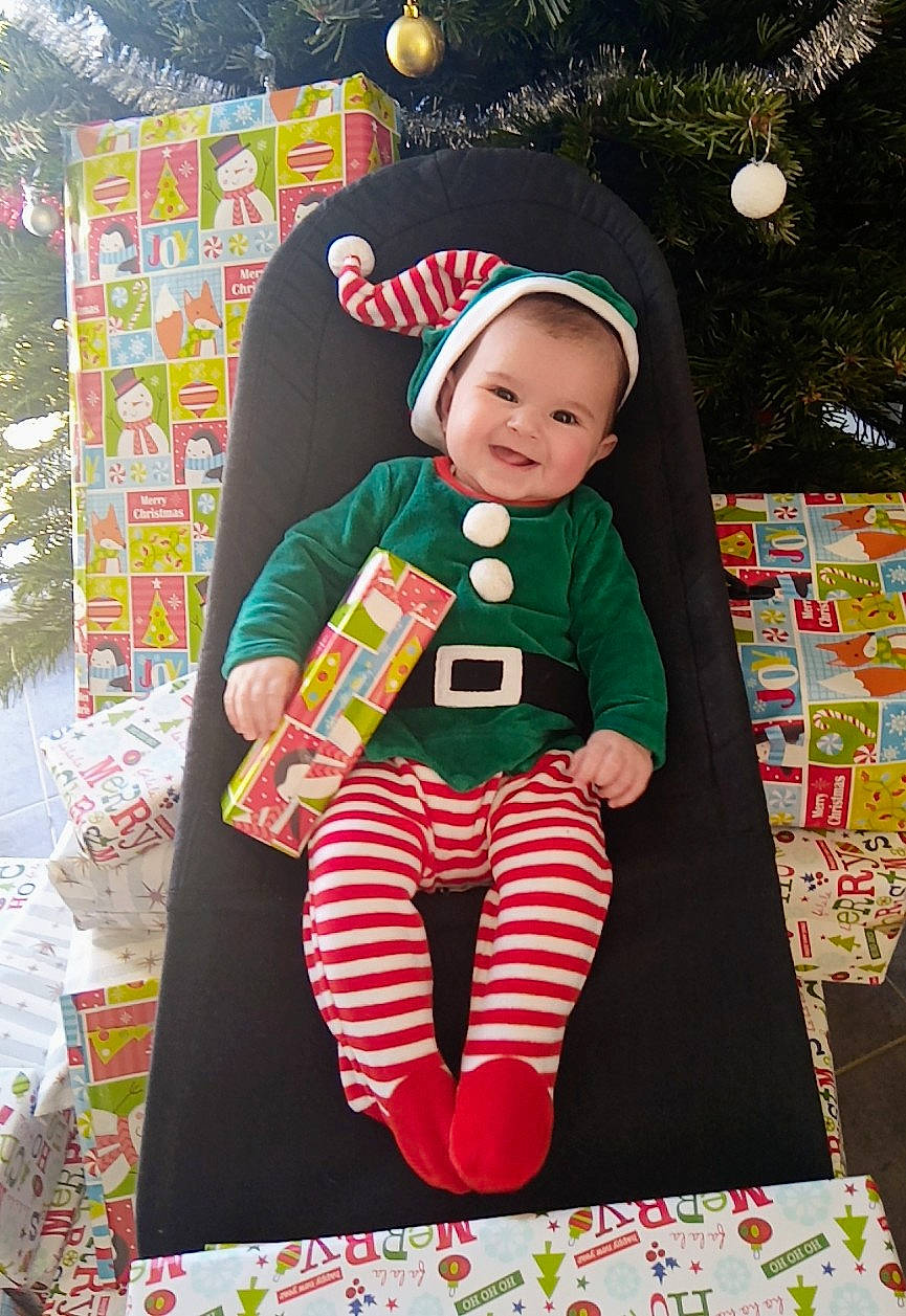 Romy participe au concours pour gagner de l'argent avec cette photo : baby, baby_products, baby_toddler_clothing, child, event, fun, happy, joy, linens, magenta, pattern, person, pink, plaid, recreation, sleeve, smile, sock, t_shirt, textile