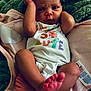 Ivori is registered to the contest to win money with this photo: baby, infant, newborn, onesie, blanket, feet, arms, face, expression, cute, soft_texture, clothing, laying_down, indoors, skin, person, young_child, sleepwear, colorful, resting