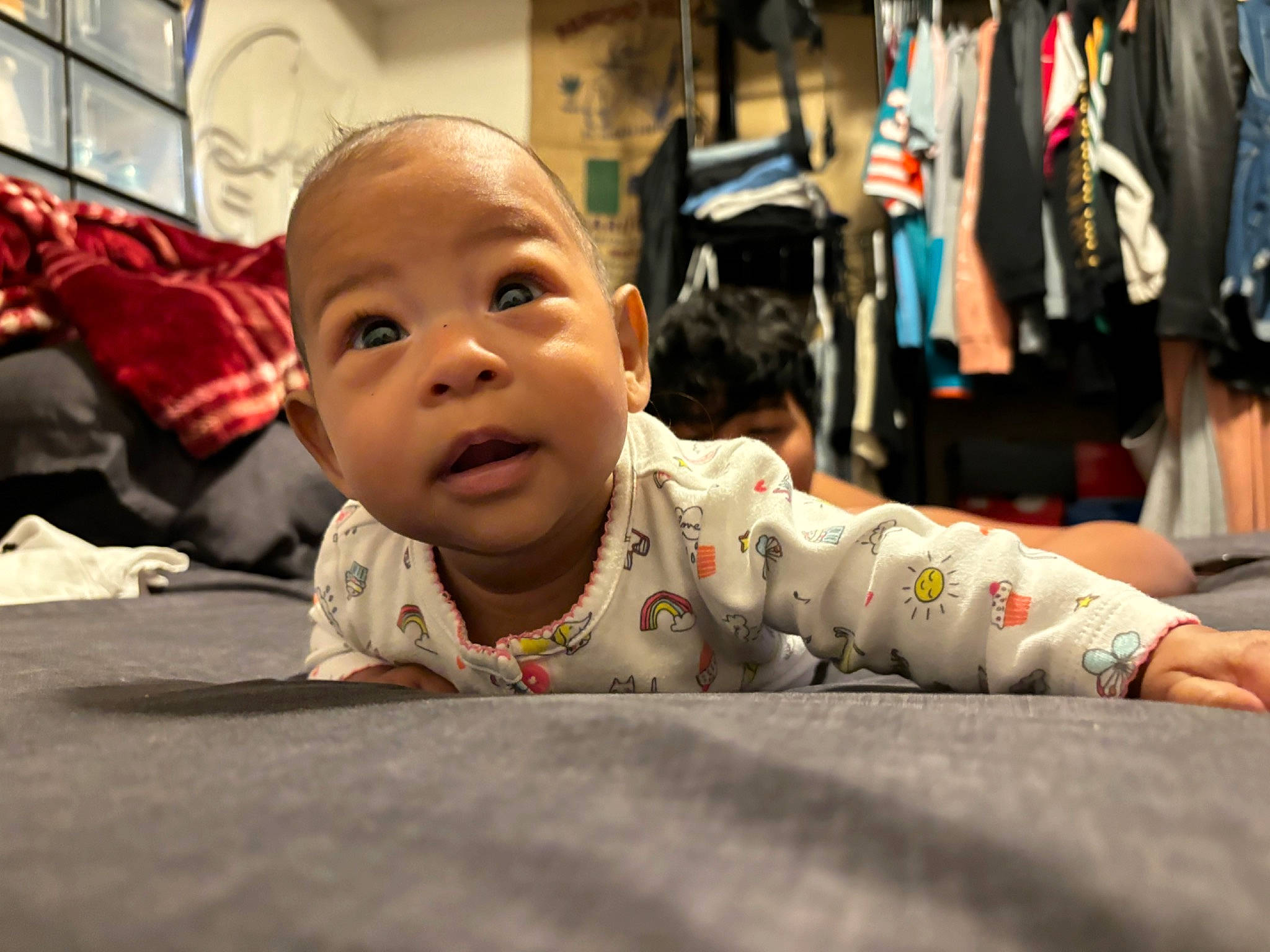 Myrical is registered to the contest to win money with this photo: baby, carmine, child, comfort, crawling, eye, floor, flooring, fun, happy, human_leg, leisure, person, public_space, room, sitting, smile, street, t_shirt, toddler