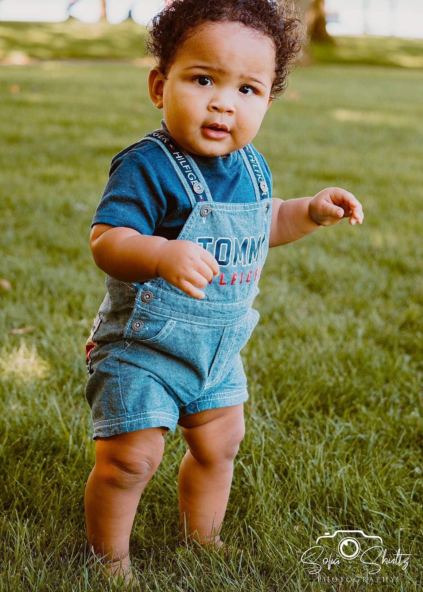 Gregory is registered to the contest to win money with this photo: baby_toddler_clothing, child, eye, face, flash_photography, gesture, grass, grassland, hair, hand, happy, head, people_in_nature, person, plant, skin, sleeve, summer, sunlight, t_shirt