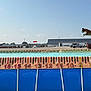 Phoenix is registered to the contest to win money with this photo: dog, jumping, pool, measuring_tape, outdoor, sky, person, cap, fence, building, truck, tractor, cloud, sunny, action, animal, sport, competition, leap, blue_sky