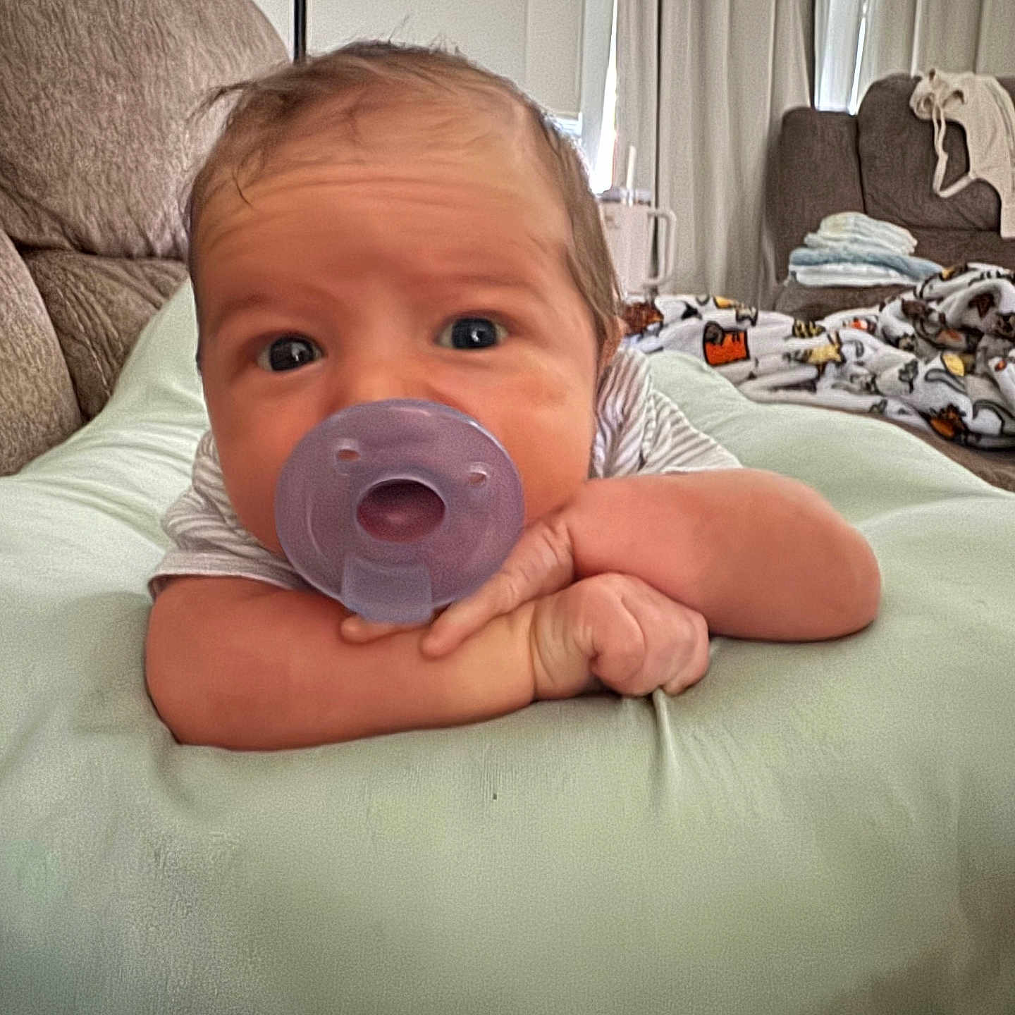 Vincent joined the competition — help win amazing prizes! baby, pacifier, cushion, infant, resting, indoor, blanket, curtains, living_room, furniture, face, skin, expression, hand, clothing, person, head, cute, young, portrait