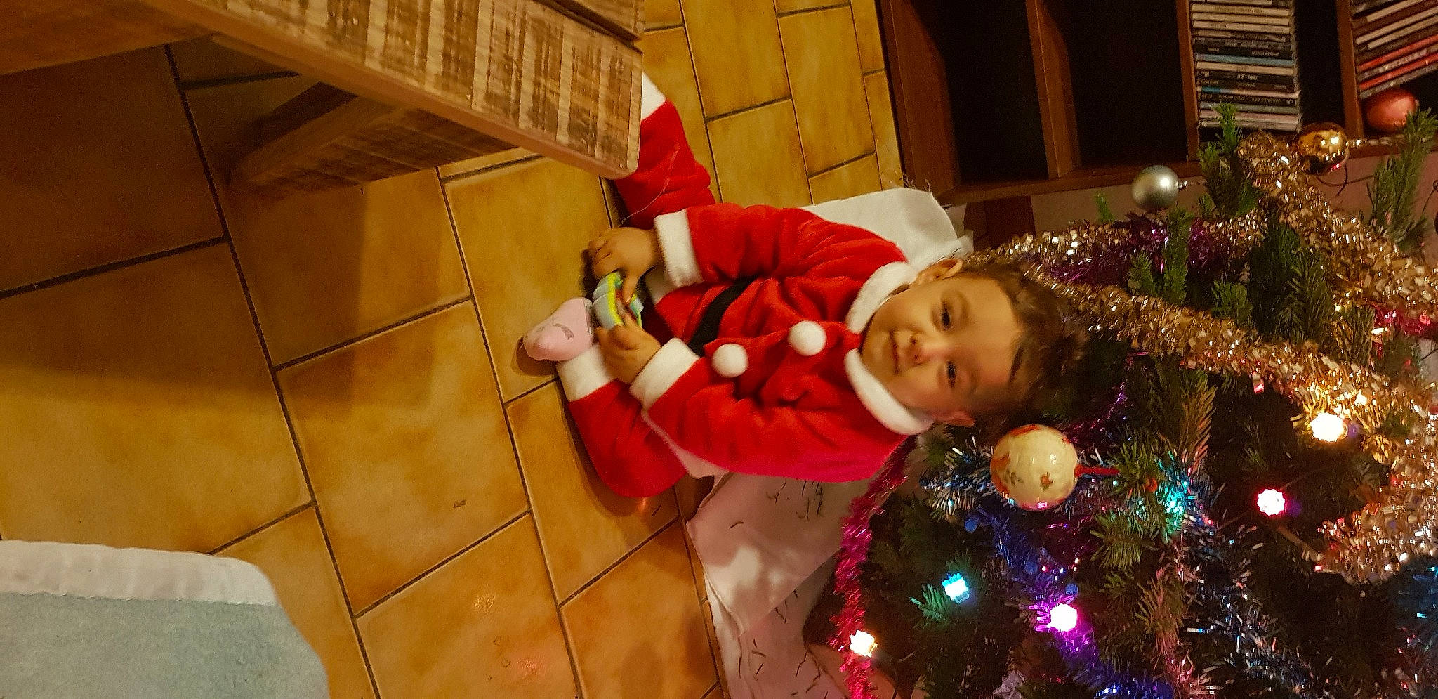 Alonzo participe au concours pour gagner de l'argent avec cette photo : child, christmas, christmas_decoration, christmas_eve, christmas_lights, christmas_ornament, christmas_tree, fictional_character, holiday, interior_design, person, santa_claus, toddler, tree