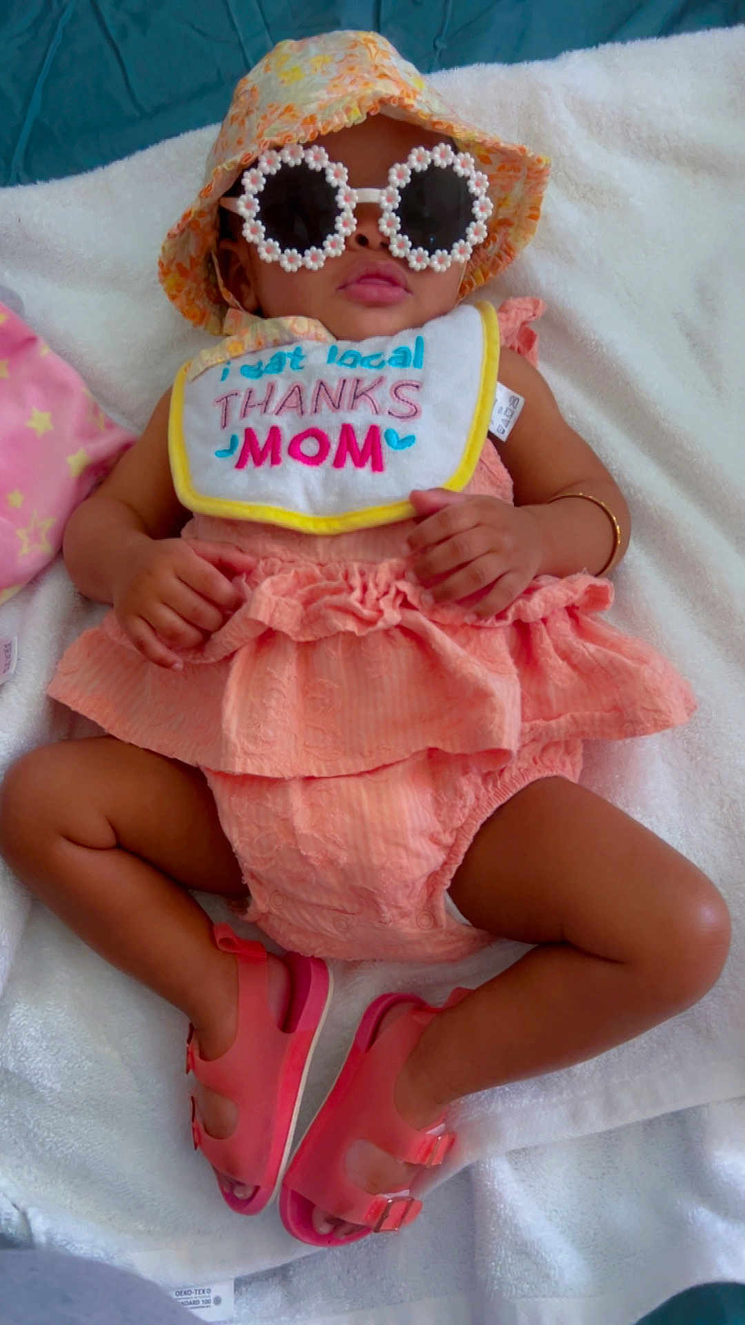 Amoura joined the competition — help win amazing prizes! baby, child, sunglasses, hat, bib, clothing, footwear, sandals, blanket, pink, peach, ruffles, flower, accessories, cute, portrait, indoor, relaxing, fashion, person