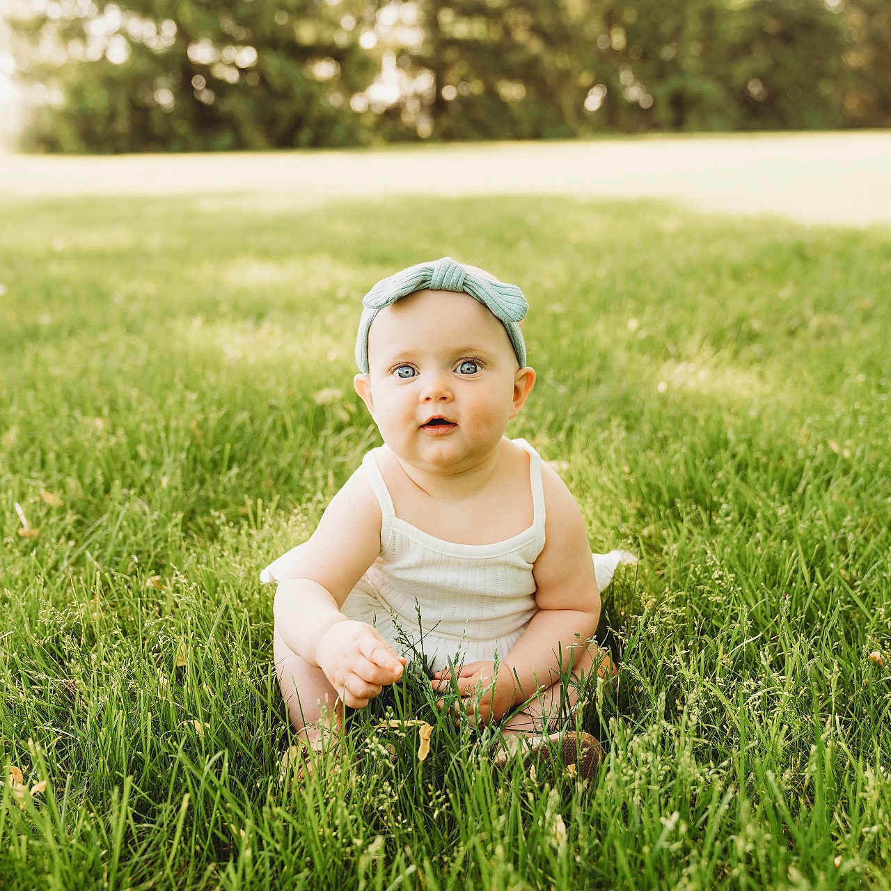 Oakleigh joined the competition — help win amazing prizes! baby, cap, clothing, face, field, grass, grassland, happy, hat, head, lawn, nature, outdoors, park, person, photography, plant, portrait, sitting, vegetation
