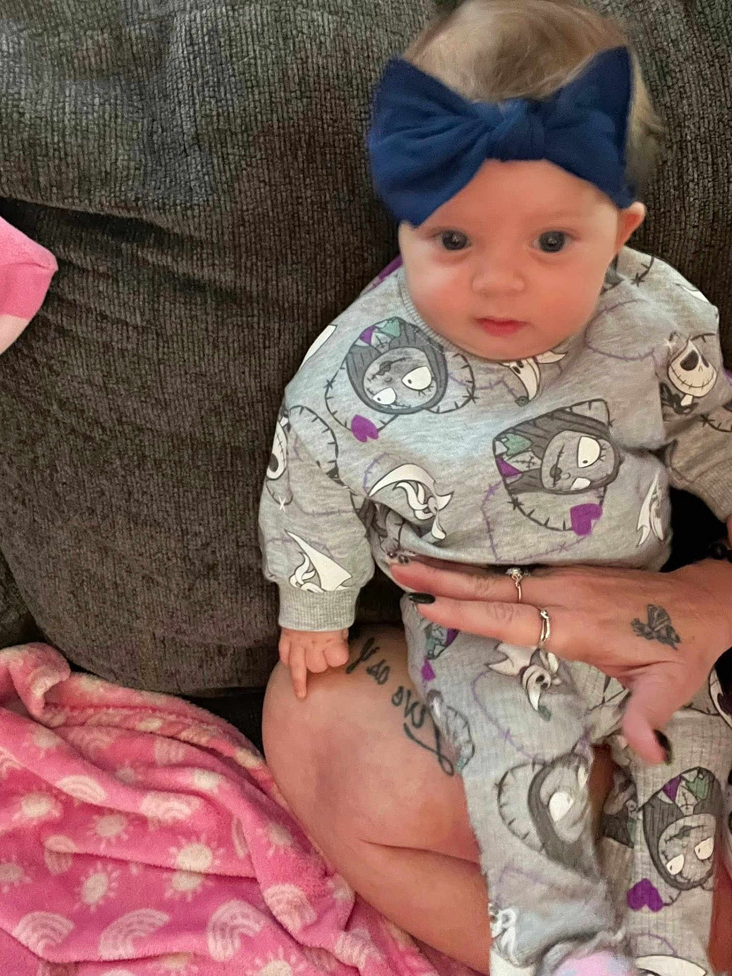 Skye is registered to the contest to win money with this photo: baby, child, infant, headband, bow, clothing, cartoon, pattern, couch, blanket, tattoo, hand, rings, person, indoor, seated, cute, portrait, fabric, soft