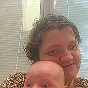 Mateo joined the competition — help win amazing prizes! baby, adult, arm, window, blinds, face, person, smile, holding, curious, indoor, light, hair, clothing, leopard_print, skin, expression, closeup, together, affection
