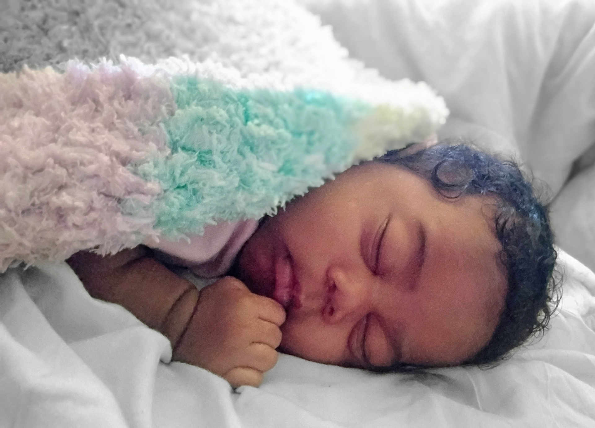 Ja'Zhyia is registered to the contest to win money with this photo: baby, sleeping, blanket, curly_hair, fist, infant, bed, rest, cozy, soft_texture, pastel_colors, peaceful, portrait, closeup, child, indoors, comfort, skin, face, toddler