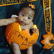 Ja'Zhyia is registered to the contest to win money with this photo: baby, black_background, bow, child, costume, cute, decor, expression, face, festive, halloween, holiday, holiday_decor, orange, person, portrait, pumpkin, sitting, small_child, tape