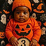 baby, bat, child, costume, cute, decor, ghost, halloween, holiday, infant, knit_hat, orange_clothing, portrait, pumpkin, seasonal, sitting, smiling, spider_web, spooky, witch_hat