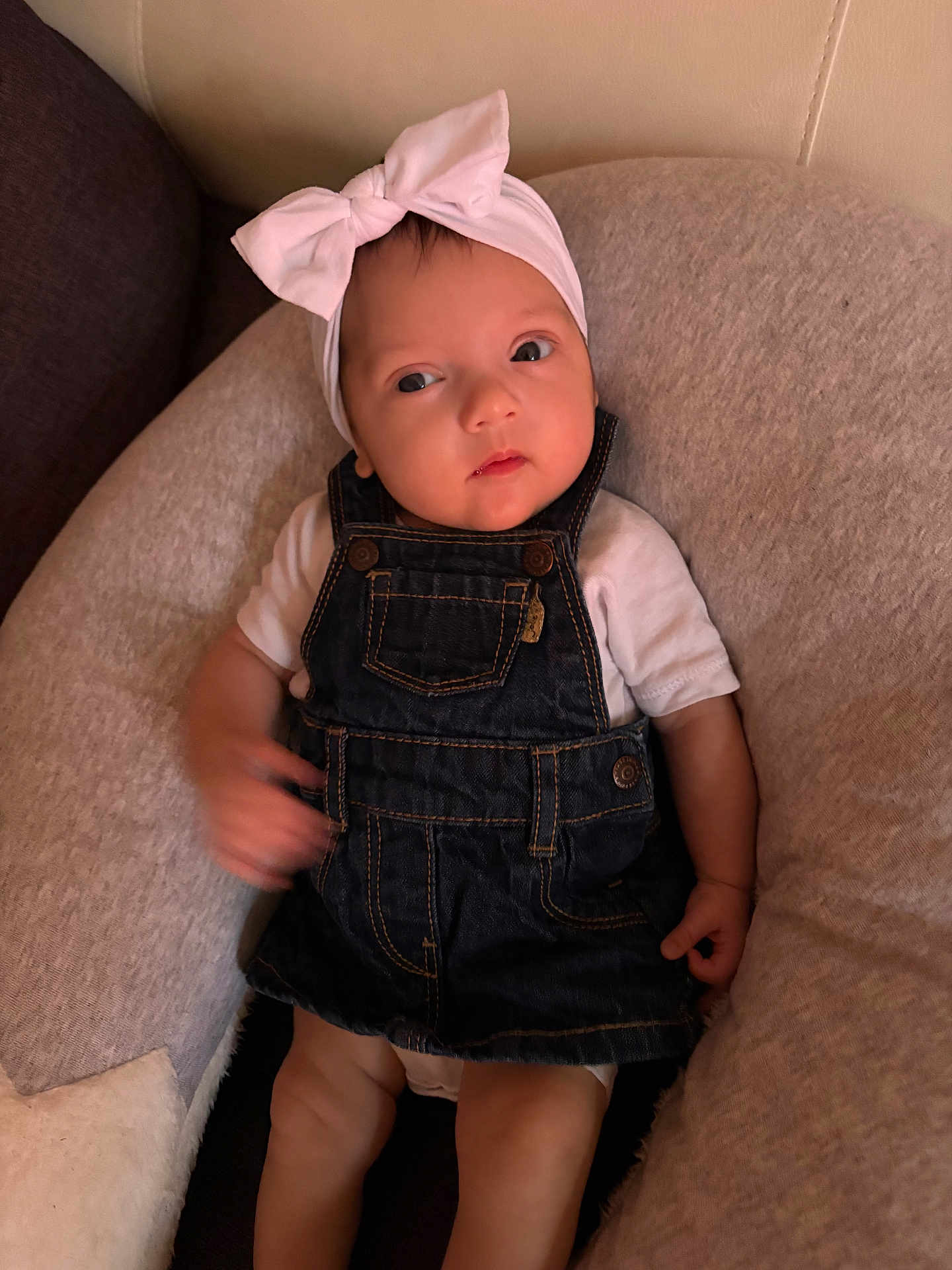 Alma a rejoint le concours — aidez-le/la à gagner de superbes lots ! baby, child, infant, headband, bow, denim_overalls, white_shirt, cushion, chair, indoor, person, skin, face, legs, hand, clothing, cute, expression, portrait, comfort