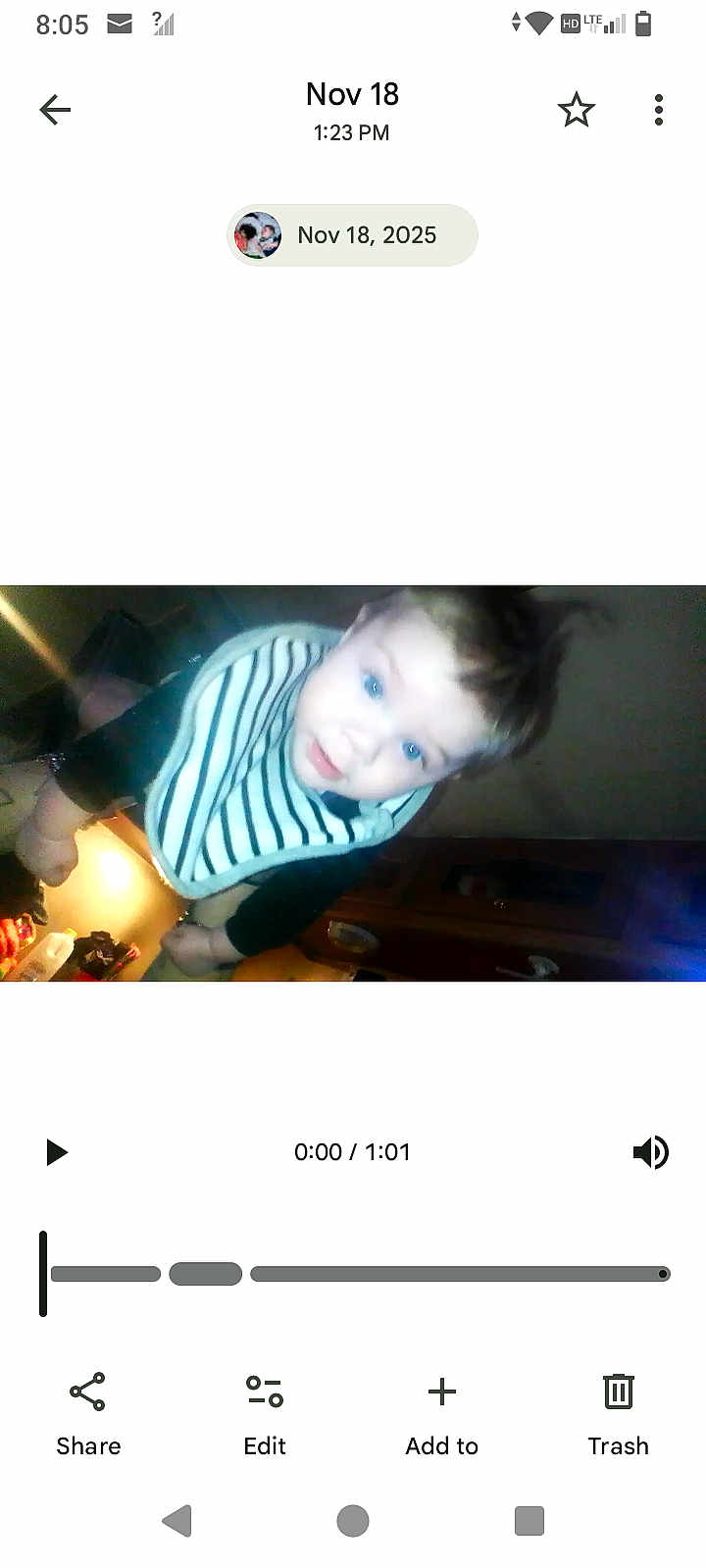 River joined the competition — help win amazing prizes! baby, infant, child, striped_bib, curious, indoor, close_up, face, blue_eyes, young_child, wearing_clothes, person, portrait, warm_light, furniture, cabinet, kitchen, blurry, head, cute