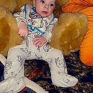 River joined the competition — help win amazing prizes! baby, infant, plush_toy, teddy_bear, onesie, animal_print, blanket, chair, indoor, child, cute, cozy, pattern, red, orange, fabric, soft_toy, home, decor, seated