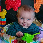 Scottie joined the competition — help win amazing prizes! baby, child, tongue_out, blue_eyes, activity_center, toys, plush_toy, giraffe_toy, striped_shirt, colorful, playful, infant, face, hand, indoor, smiling, seat, cute, expression, young_child