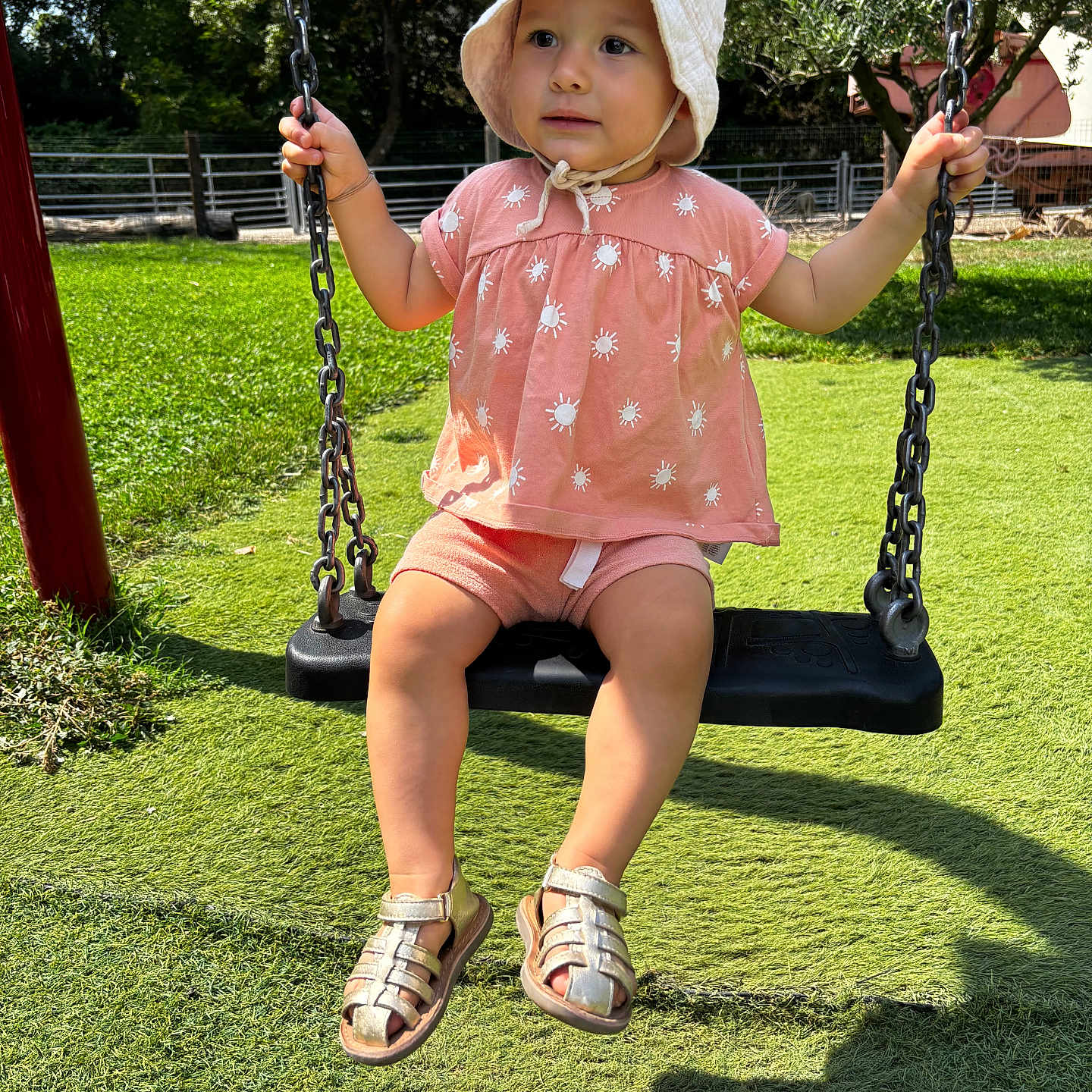 Maylie participe au concours pour gagner de l'argent avec cette photo : baby, chains, child, cute, daylight, expression, fun, grass, hat, nature, outdoor, park, pink_clothing, playground, sandals, summer, sunlight, swing, toddler, trees