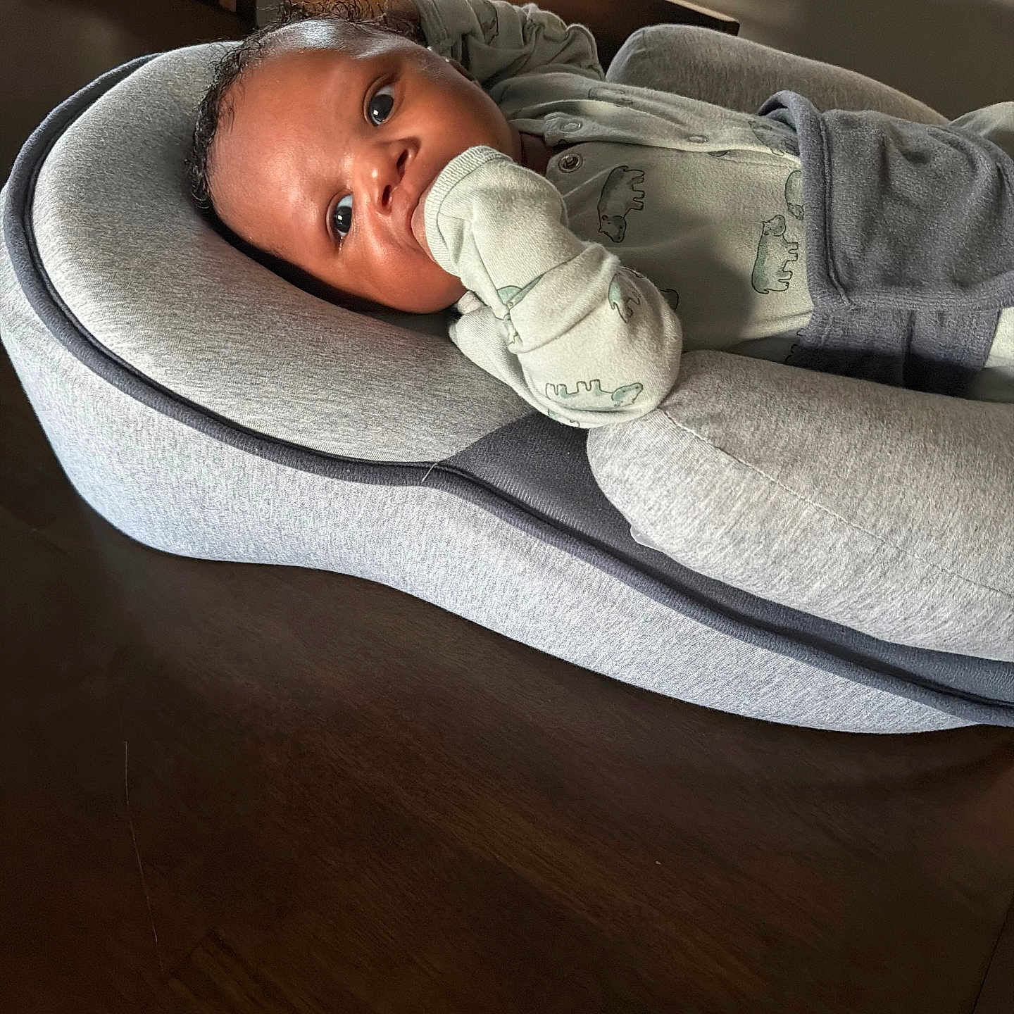 Kj joined the competition — help win amazing prizes! baby, infant, baby_nest, gray, wooden_table, clothing, sleeve, face, hand, curious, indoors, person, newborn, baby_garment, resting, child, young, portrait, cozy, furniture