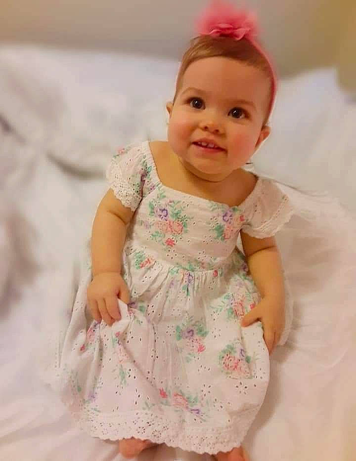 Azula is registered to the contest to win money with this photo: baby, baby_toddler_clothing, cheek, child, clothing, dress, hair_accessory, joy, pattern, person, pink, skin, smile, toddler