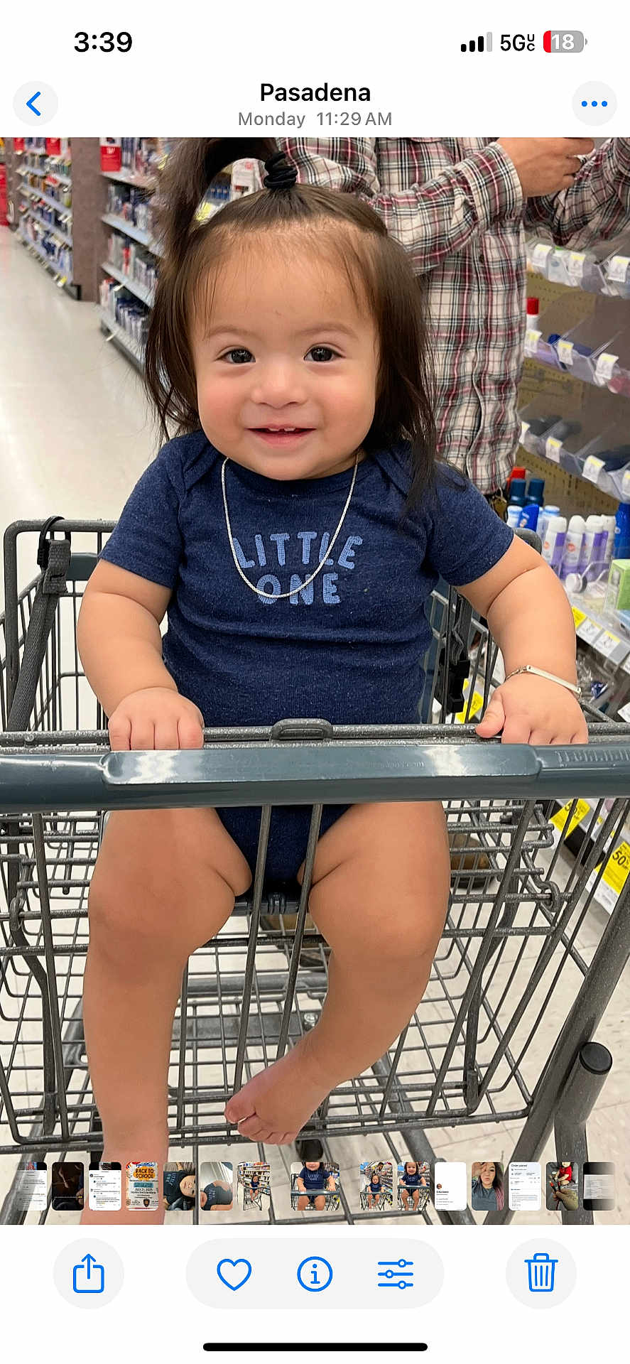 Landon is registered to the contest to win money with this photo: toddler, child, shopping_cart, smile, blue_shirt, necklace, hair_tie, supermarket, aisle, adult_hand, plaid_shirt, legs, barefoot, metal_cart, retail, casual_clothing, cute, portrait, indoor, happy