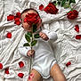 adorable, baby, bed, cute, flower_stem, green_leaves, hand, infant, kiss_mark, legs, lipstick_mark, lying_down, onesie, portrait, props, red_rose, rose, rose_petals, soft_light, white_sheet