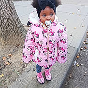 Xena is registered to the contest to win money with this photo: child, city, clothing, coat, face, female, girl, head, hood, jacket, path, person, photography, plant, portrait, road, sidewalk, street, toy, urban