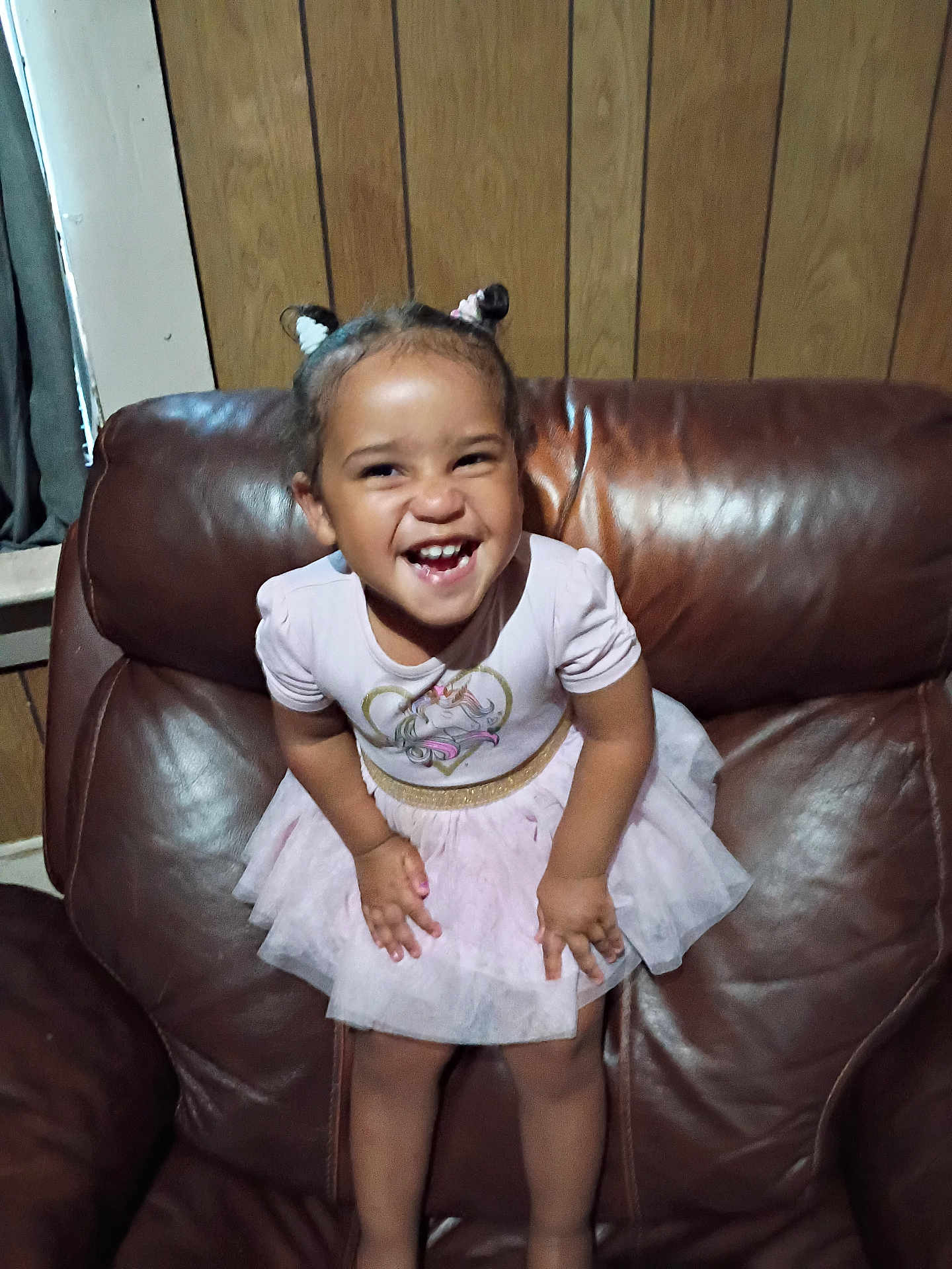 Evelyn joined the competition — help win amazing prizes! child, toddler, smiling, happy, dress, unicorn, pink, hair_buns, leather_chair, armchair, wood_paneling, indoor, cute, person, fun, joy, small_child, portrait, clothing, furniture