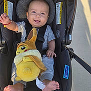 Dario joined the competition — help win amazing prizes! baby, child, infant, smiling, happy, car_seat, plush_toy, dinosaur_toy, outdoor, sunlight, portrait, face, eyes, waving, striped_shirt, pants, bare_feet, travel, stroller, sitting