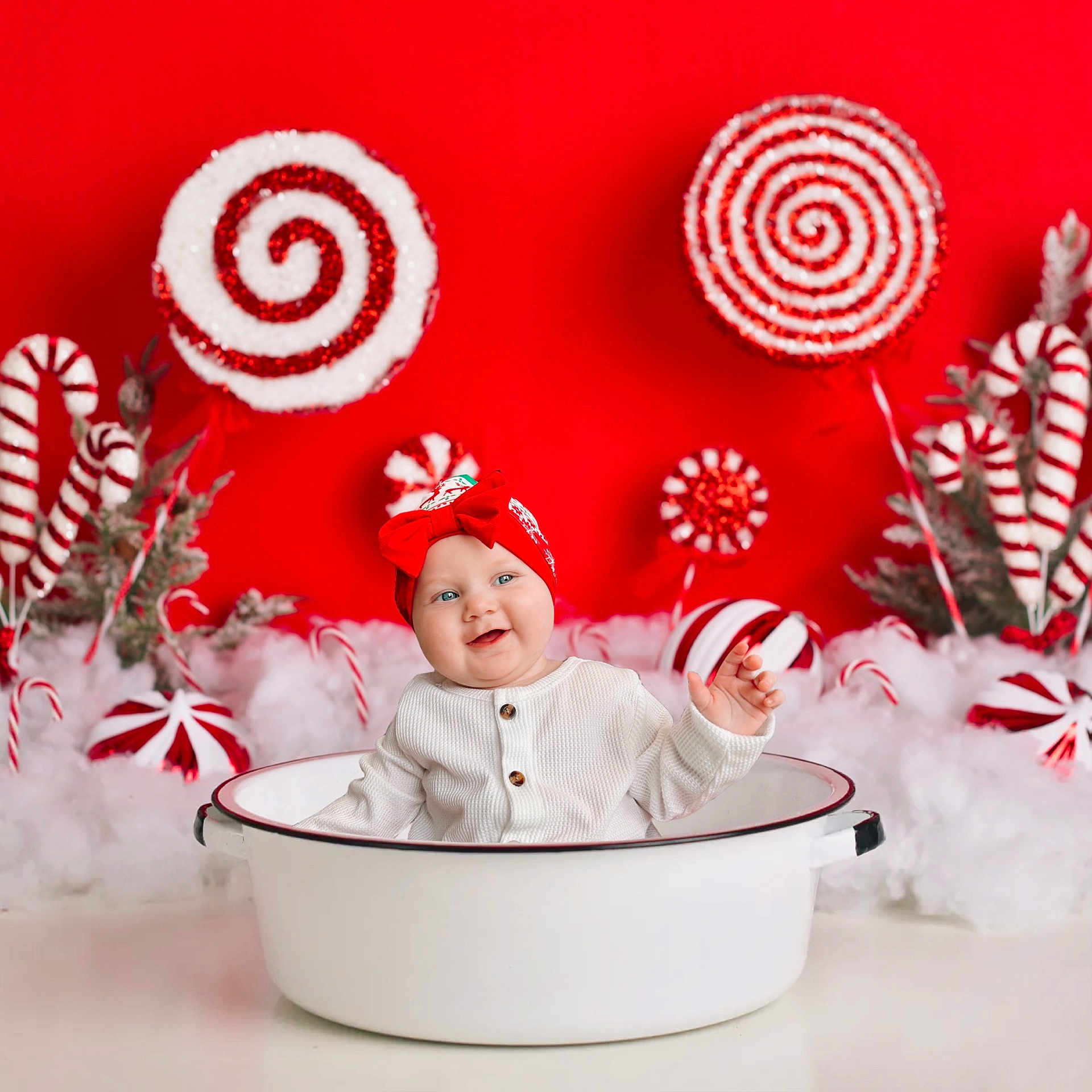 Camilah is registered to the contest to win money with this photo: baby, blue_eyes, candy_cane, child, christmas, cute, decorations, festive, holiday_theme, indoors, infant, joyful, photography, playful, portrait, red_background, red_bow, smiling, white_basin, white_clothing