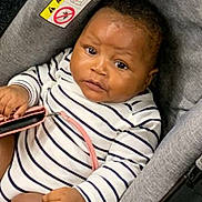 Riyad a rejoint le concours — aidez-le/la à gagner de superbes lots ! baby, black_hair, car_seat, child, closeup, cute, expression, fabric, face, fingernails, hand, holding, indoor, infant, person, seatbelt, sitting, striped_clothing, warning_label, young_child