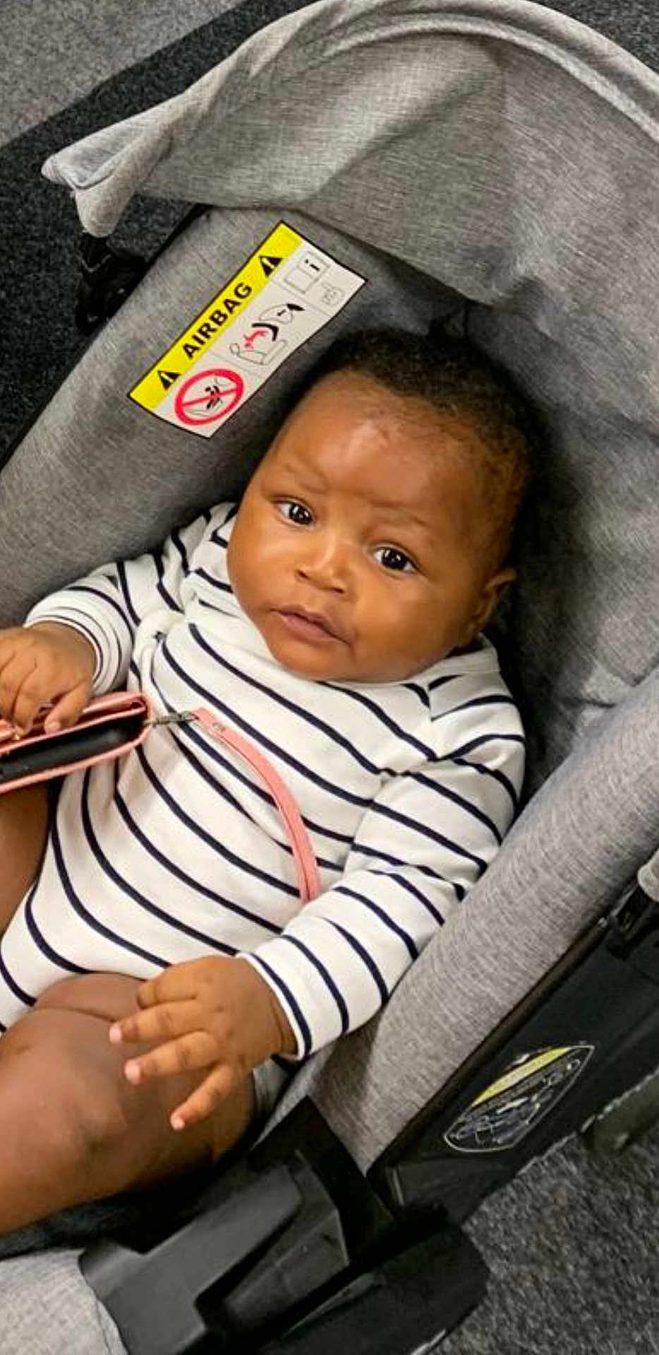 Riyad a rejoint le concours — aidez-le/la à gagner de superbes lots ! baby, black_hair, car_seat, child, closeup, cute, expression, fabric, face, fingernails, hand, holding, indoor, infant, person, seatbelt, sitting, striped_clothing, warning_label, young_child