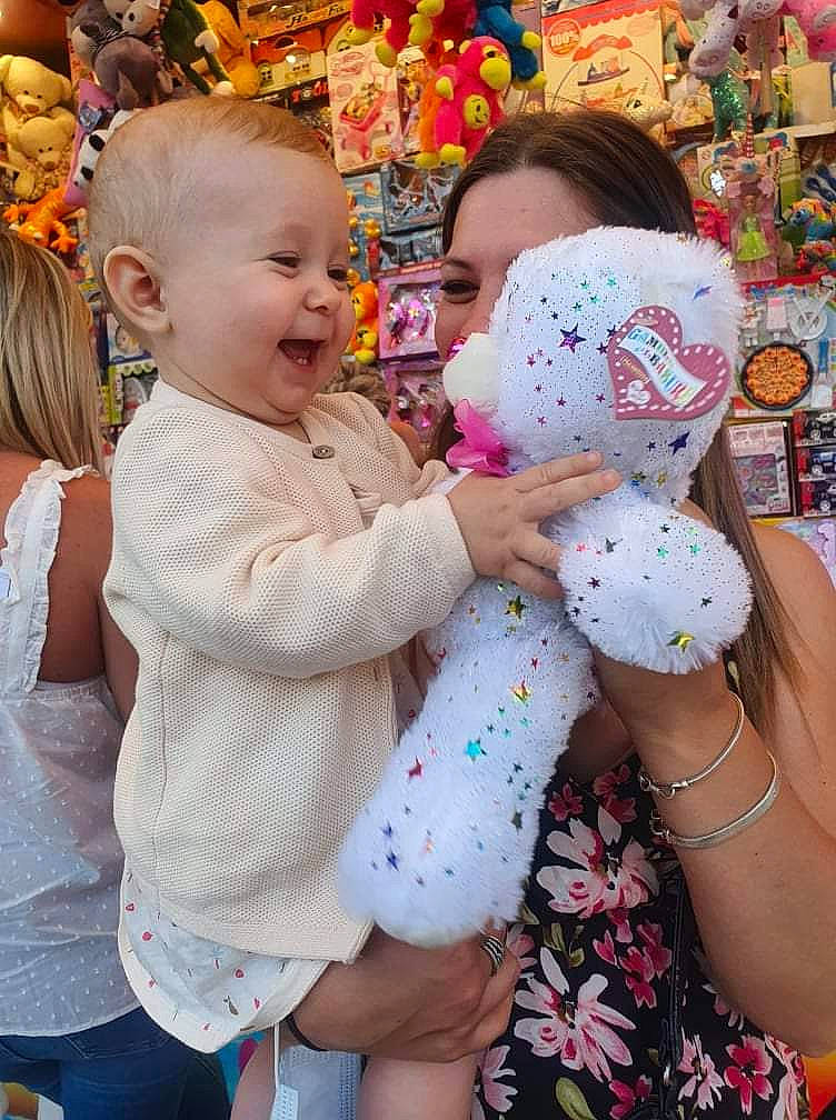 Lara participe au concours pour gagner de l'argent avec cette photo : baby, child, event, fun, gesture, happy, head, holiday, interaction, leisure, party_supply, person, pink, sitting, skin, stuffed_toy, t_shirt, textile, toddler, toy