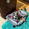 puppy, dog_bed, blanket, rug, toy, luigi_plush, tile_floor, indoor, pet, cute, small_dog, resting, cozy, brown_and_white, playful, floor_mat, home, animal, comfort, young_dog