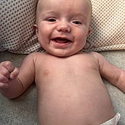 Kayson is registered to the contest to win money with this photo: baby, infant, smile, diaper, cute, face, skin, pillow, blanket, lying_down, happy, child, fist, expression, indoors, human, newborn, cheerful, portrait, toddler