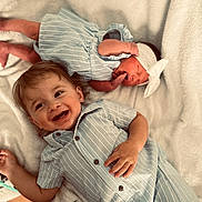 Kyler James joined the competition — help win amazing prizes! baby, child, newborn, siblings, smiling, happy, portrait, cute, infant, headband, clothing, striped, bed, blanket, laying_down, family, toddler, soft_texture, indoor, person