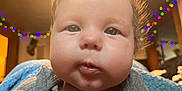 Adalynn Rose is registered to the contest to win money with this photo: baby, child, face, indoor, close_up, cute, chubby_cheeks, expression, curious, soft_lighting, blurry_background, fairy_lights, colorful_lights, portrait, young_child, infant, gray_shirt, skin, person, head