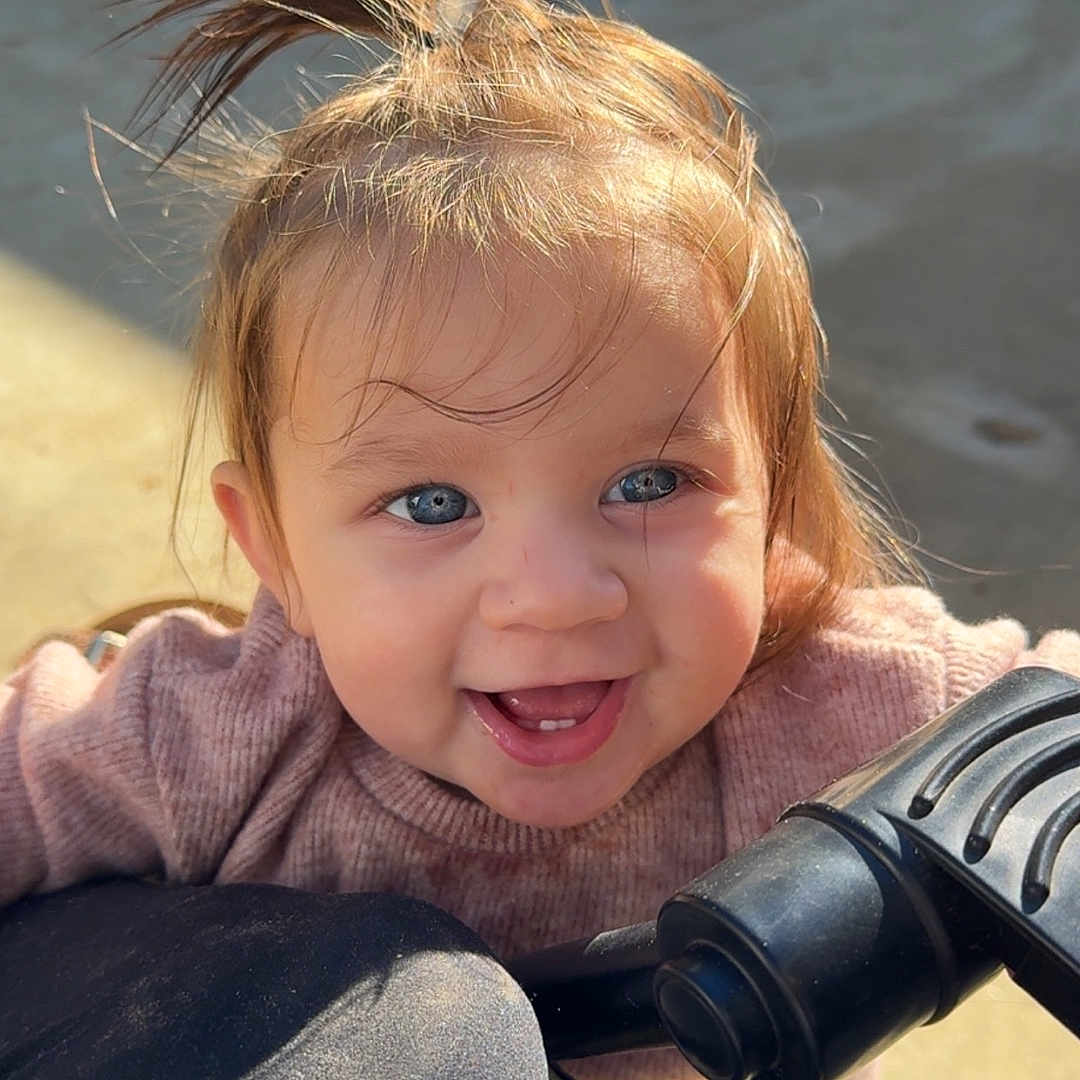 Selah joined the competition — help win amazing prizes! baby, blue_eyes, casual, child, cute, daylight, expression, face, hair_tuft, happy, outdoor, person, playful, portrait, smiling, stroller, sunlight, sweater, toddler, young_child