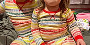 Isla is registered to the contest to win money with this photo: child, children, pajamas, bed, smiling, sitting, indoor, curtains, red_wall, drawing, happy, cute, person, playful, colorful_clothing, two_people, young, face, hair, cozy