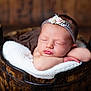 newborn, baby, sleeping, headband, flower, wooden_bucket, blanket, knitted, resting, portrait, infant, peaceful, cute, soft_light, indoors, wooden_floor, closeup, child, baby_face, adorable
