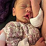 newborn, baby, infant, sleeping, portrait, face, closed_eyes, floral_outfit, blanket, cozy, snuggling, adult_arm, tiny_fist, indoors, close_up, peaceful, resting, cute, family, photography