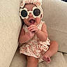Navy joined the competition — help win amazing prizes! baby, child, sunglasses, flower_shaped, headband, smiling, happy, clapping, couch, beige, dress, patterned, infant, cute, indoor, portrait, hand, foot, relaxing, funny