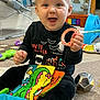 Giovanni is registered to the contest to win money with this photo: baby, child, smiling, indoor, toy, carpet, halloween, clothing, sitting, playroom, face, person, cushion, rocker, colorful, happy, infant, cute, floor, fun