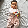 baby, bed, blanket, bodypart, clothing, couch, dress, face, finger, furniture, hand, happy, head, pants, person, photography, portrait, shorts, smile, toy