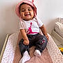 baby, babylaughing, bonnet, cap, clothing, cushion, face, furniture, happy, hat, head, homedecor, hosiery, pants, person, photography, portrait, sitting, smile, sock