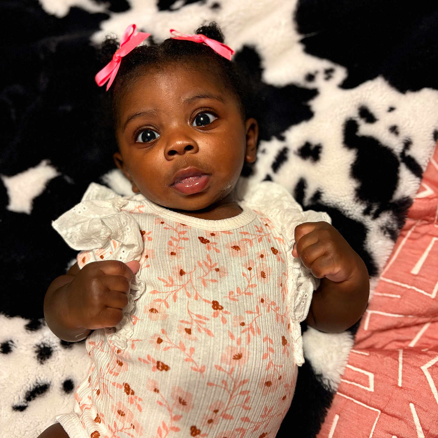 Nova joined the competition — help win amazing prizes! baby, infant, child, portrait, face, eyes, hair_bow, onesie, floral_pattern, blanket, black_and_white, pink, cute, expression, lying_down, indoor, skin, hand, fist, young