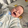 baby, smiling, face, onesie, bed, crib, winnie_the_pooh, sheet, child, happy, infant, lying_down, cute, indoor, person, plush, soft, clothing, portrait, expression