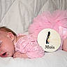 baby, celebration, child, clothing, cute, indoors, infant, lace, milestone, newborn, one_month, peaceful, pink, portrait, resting, sleeping, soft, tutu, white_background, wooden_sign