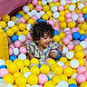 Dawud joined the competition — help win amazing prizes! ball_pit, blue_balls, child, colorful_balls, curly_hair, cute, fun, happy, indoor, joy, person, pink_balls, play, smiling, striped_shirt, toddler, translucent_balls, white_balls, wristband, yellow_balls