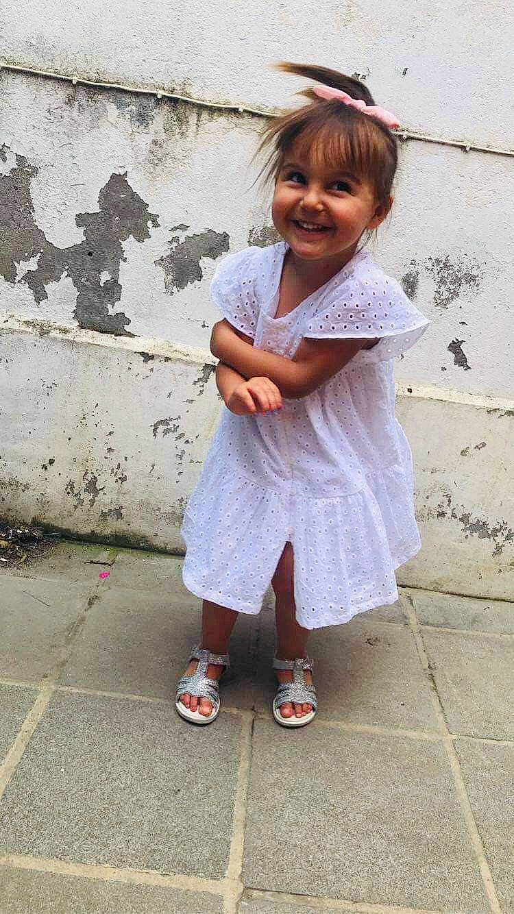 Maëly participe au concours pour gagner de l'argent avec cette photo : baby_toddler_clothing, child, concrete, flip_flops, foot, footwear, fun, happy, human_leg, joy, pattern, person, pink, sandal, shoe, sitting, sleeve, slipper, smile, sock