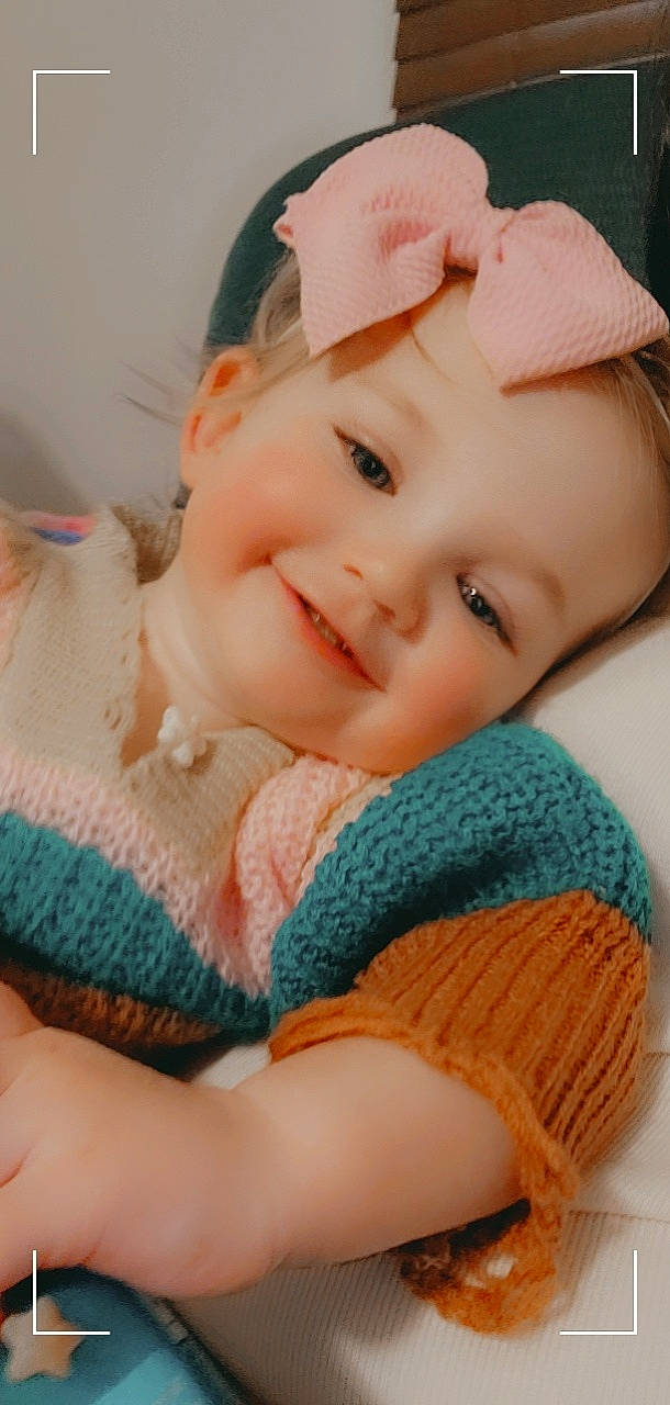 Angela is registered to the contest to win money with this photo: baby, baby_toddler_clothing, cap, cheek, eye, eyelash, face, happy, head, headwear, human_body, iris, joy, lip, mouth, nose, outerwear, person, pink, skin